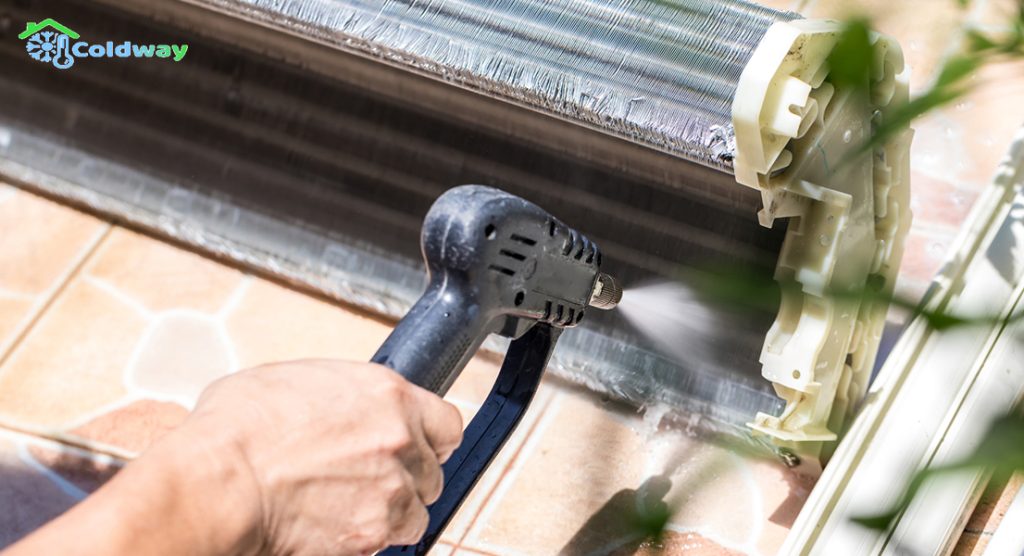 A technician performing a chemical overhaul on the aircon coil