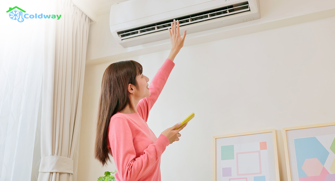 A woman checking the aircon unit for cold air