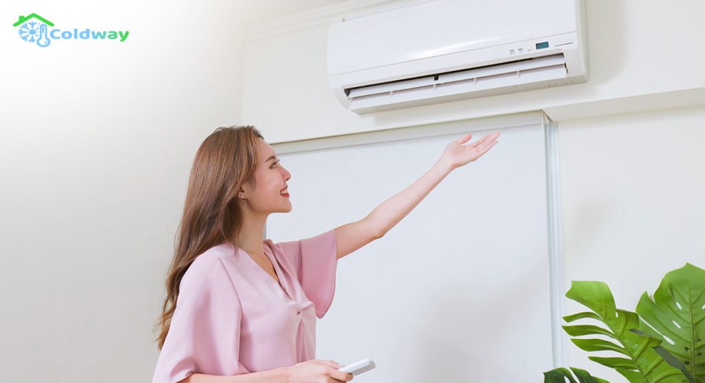 A woman with her arm raised, checking the air conditioner quality