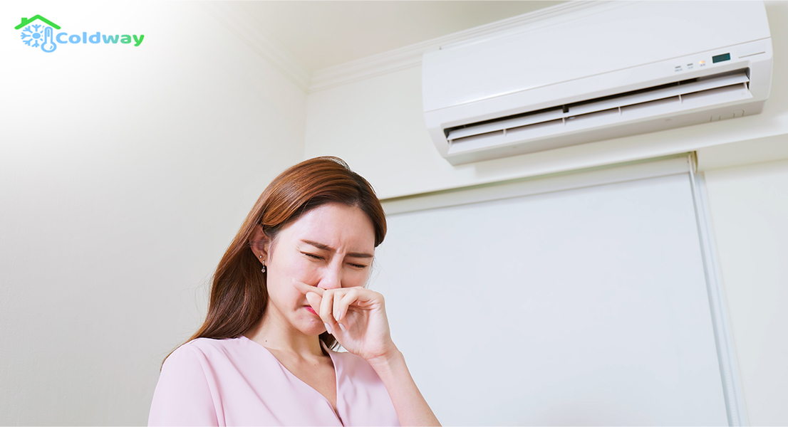 Woman covering her nose in disgust due to odor from air-con.